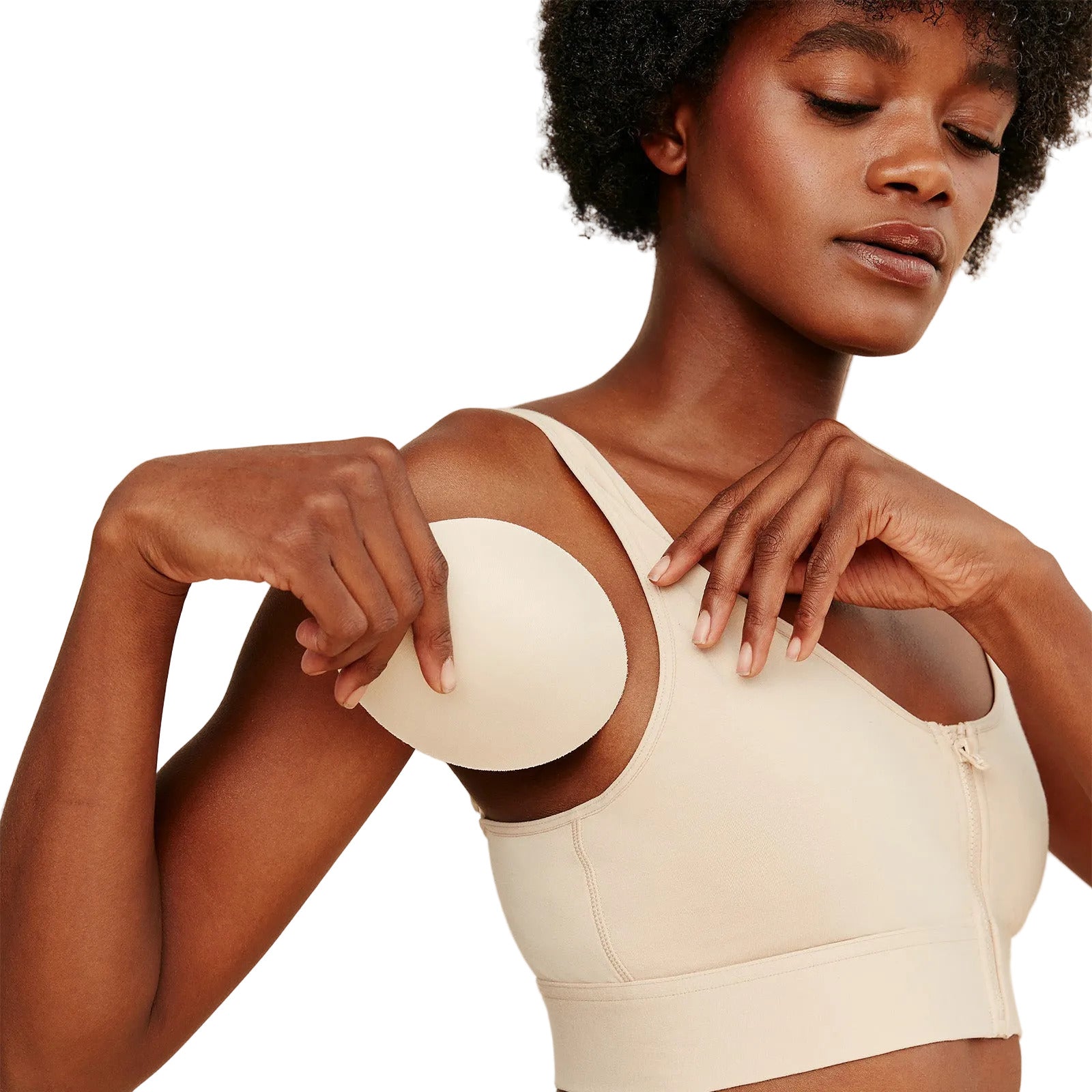 Woman wearing a beige sports bra against a white background